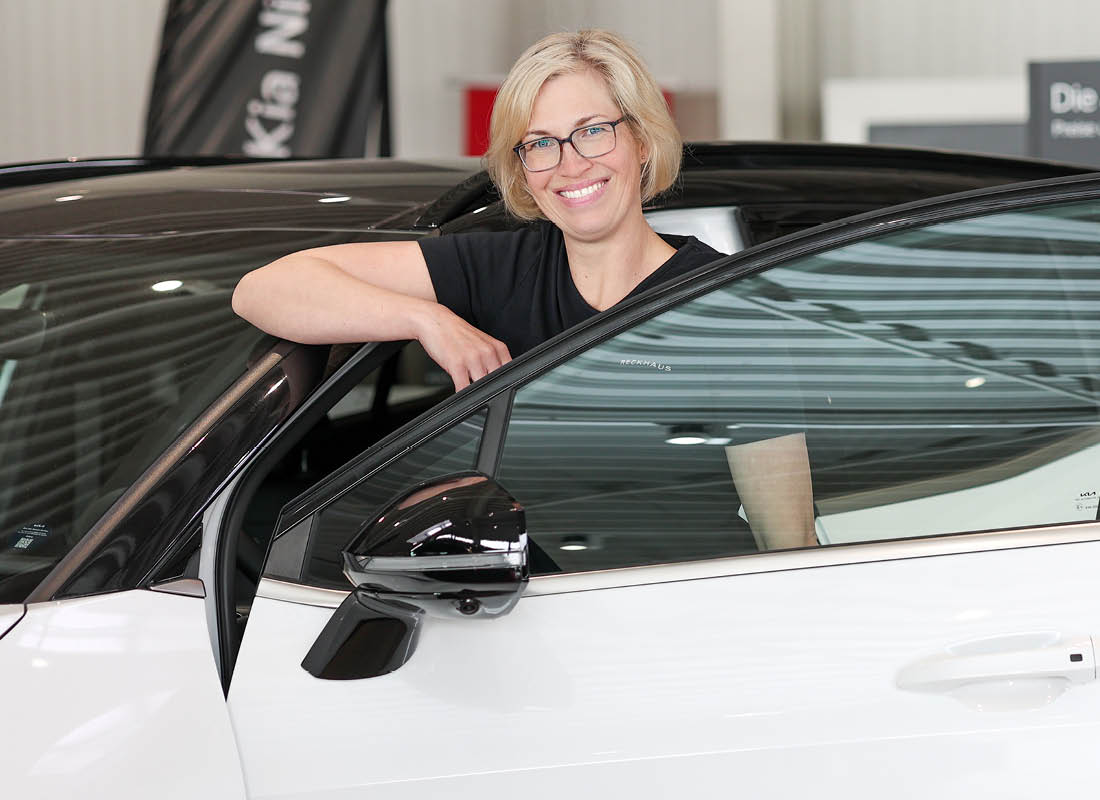 Frau Reckhaus steht an einer Autotür