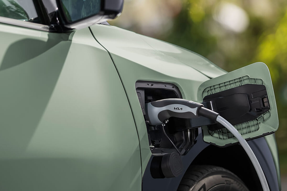 Man sieht den Kia EV3 in Nahaufnahme beim Laden mit dem E-Ladekabel.