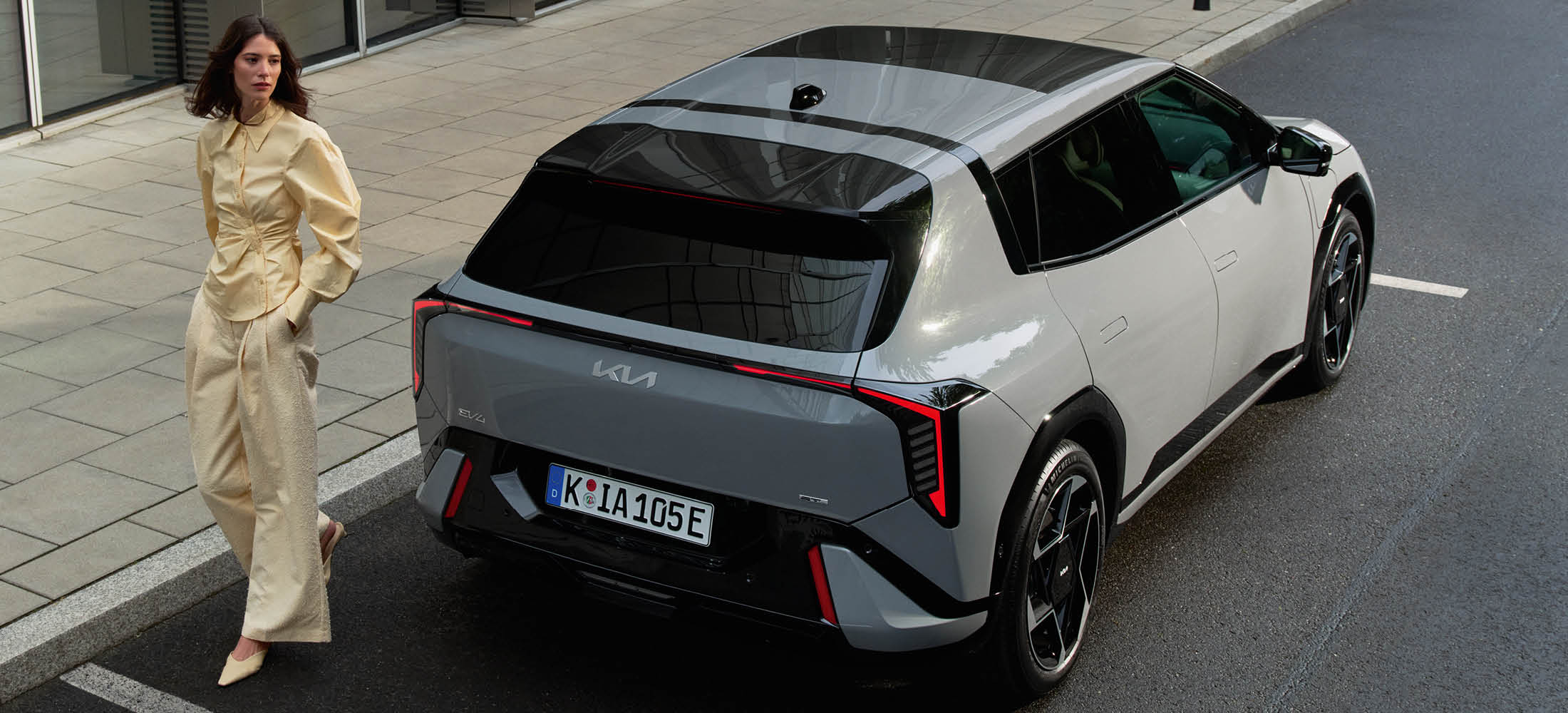 Frau läft am Kia EV4 vorbei