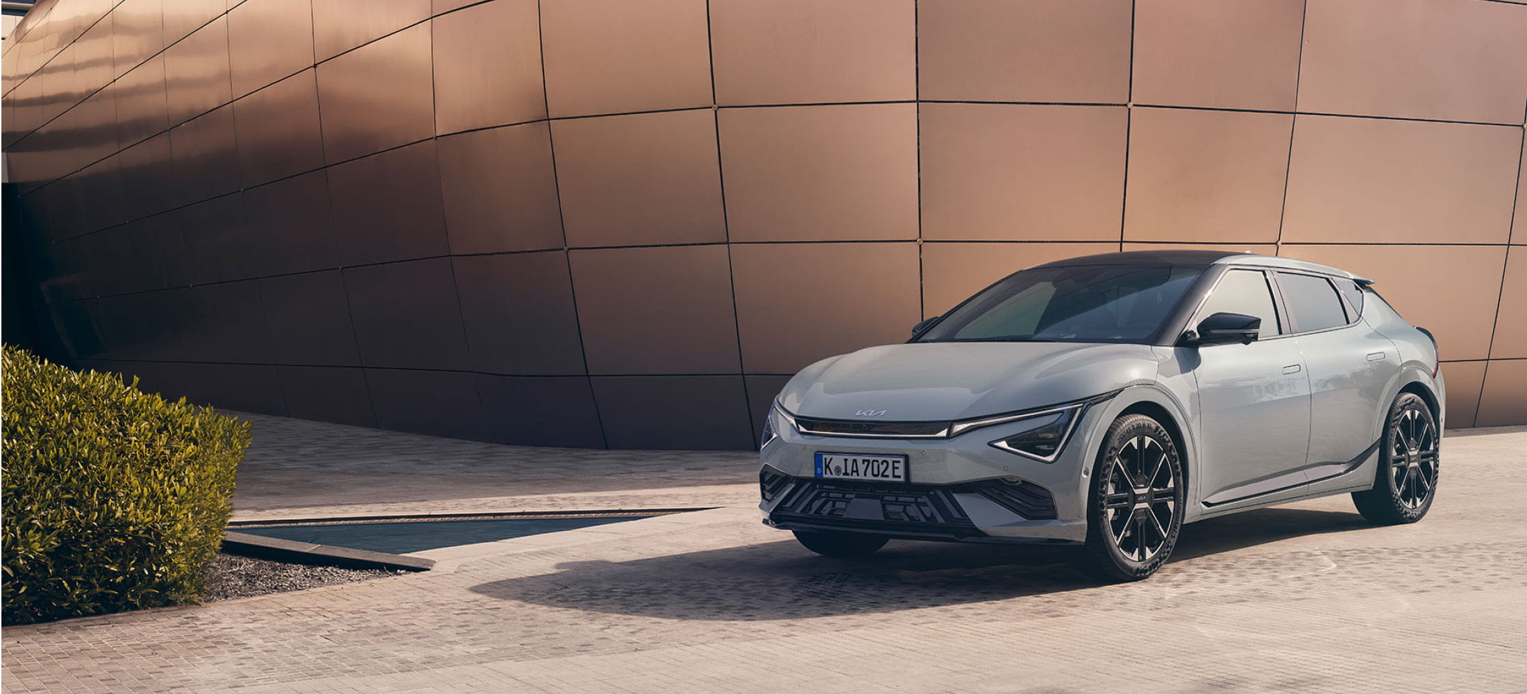 Outlander steht auf einer Plattform im Hintergrund blauer Himmel und Berglandschaft