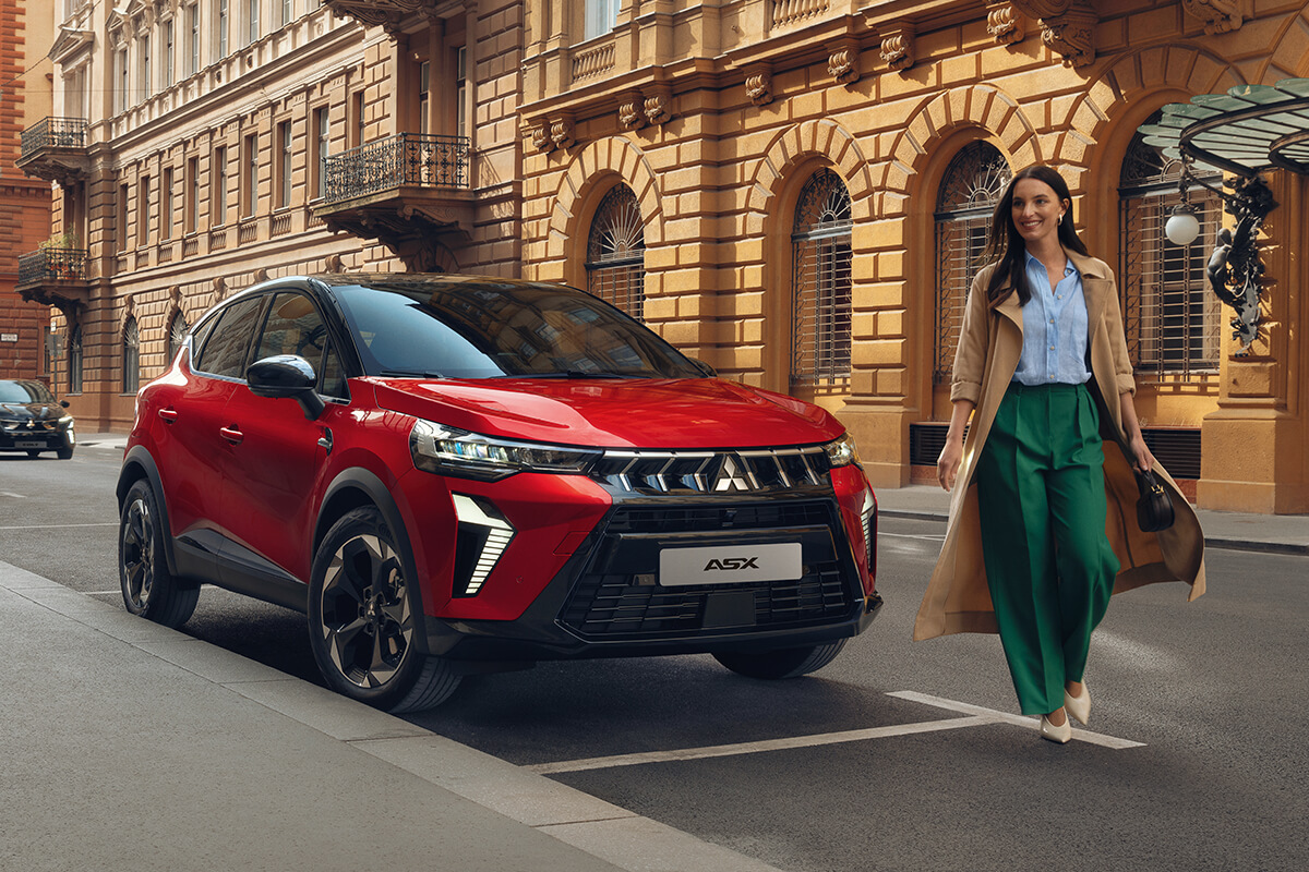 Mitsubishi ASX stegt auf einem Parplatz, eine Frau geht vor das Auto